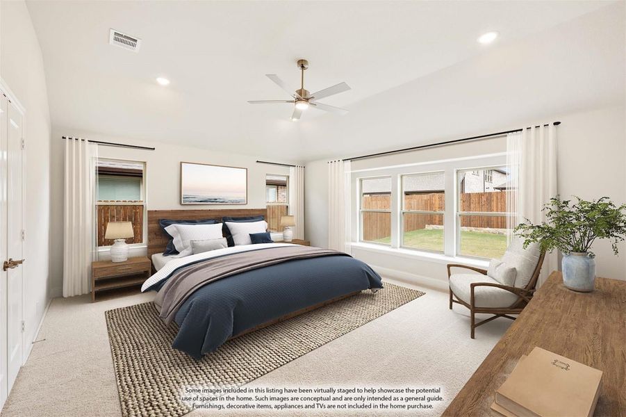 Spacious bedroom with wood headboard, ceiling fan, carpet flooring, and large windows overlooking backyard
