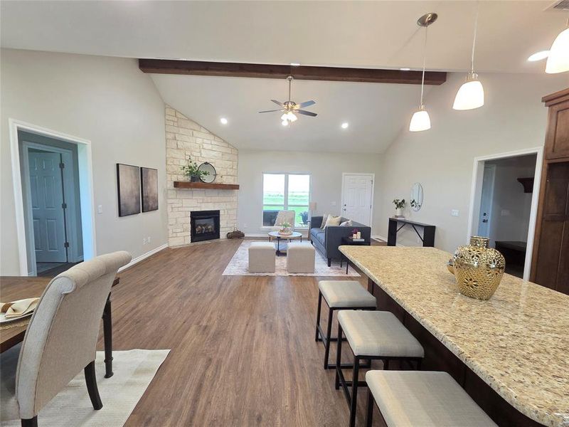 Dining room featuring dark wood-style floors, beamed ceiling, a ceiling fan, a fireplace, and high vaulted ceiling Dining room featuring dark wood-style floors, beamed ceiling, a ceiling fan, a fireplace, and high vaulted ceiling