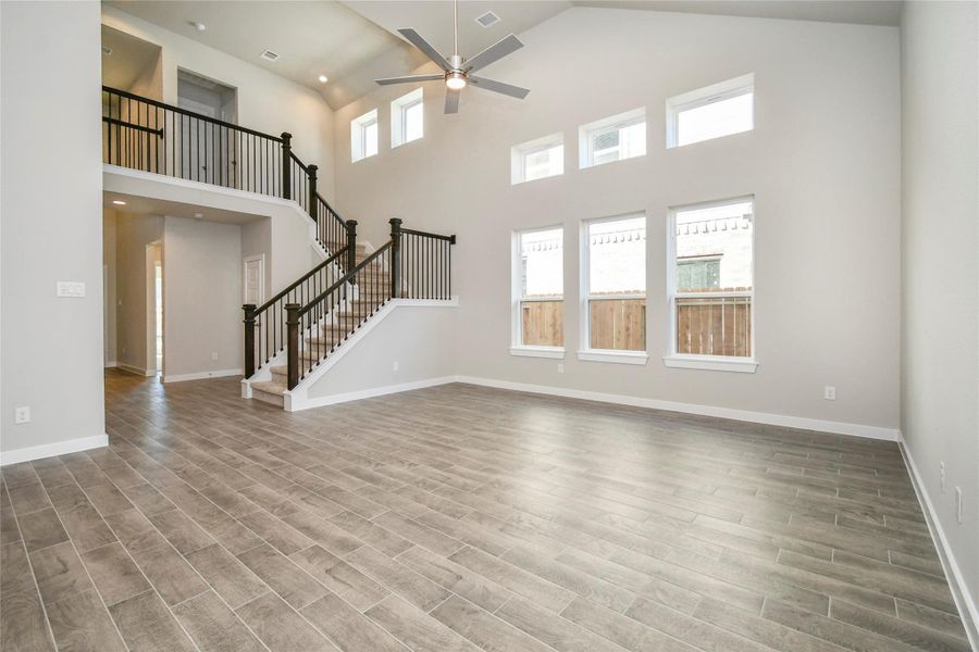 Welcome family and guests to your charming living room! With its high ceilings,recessed lighting, ceiling fan, custom paint, beautiful flooring, and large windows that letin abundant natural light, this room is perfect for gatherings. Sample photo of completed home with similar floor plan. Actual colors and selections may vary.