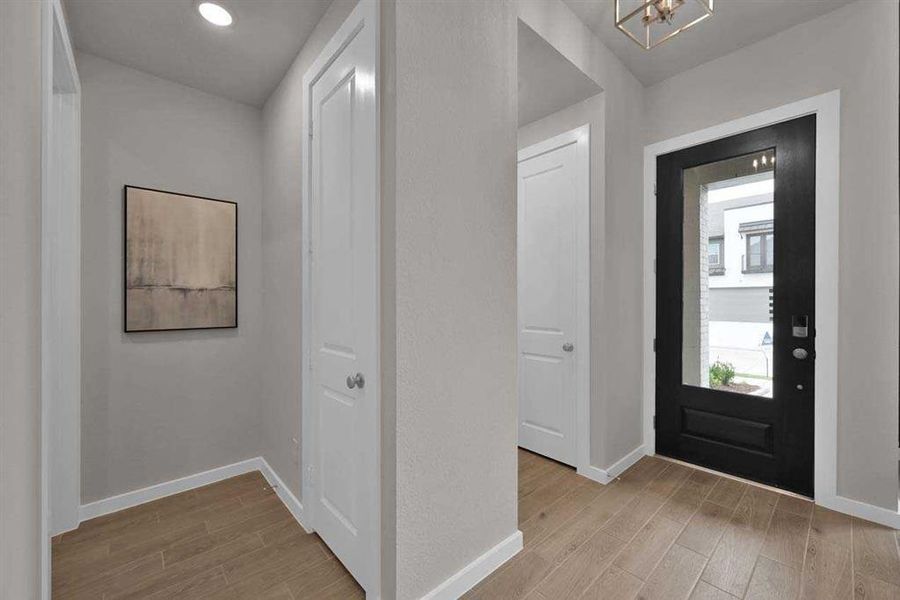 Contemporary glass-paneled front door welcomes you inside with natural light.