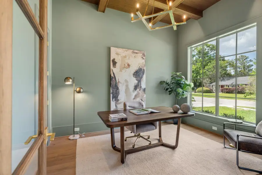 A dedicated study offers a quiet retreat with large windows that bring in natural light. A coffered ceiling detail adds architectural interest, while the enclosed layout provides both privacy and functionality.