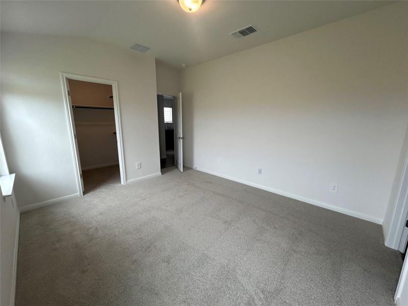 Unfurnished bedroom featuring carpet floors and a spacious closet