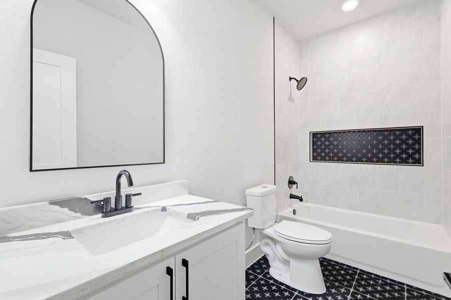 Full bath with washtub / shower combination, vanity, dark tile patterned flooring, and recessed lighting