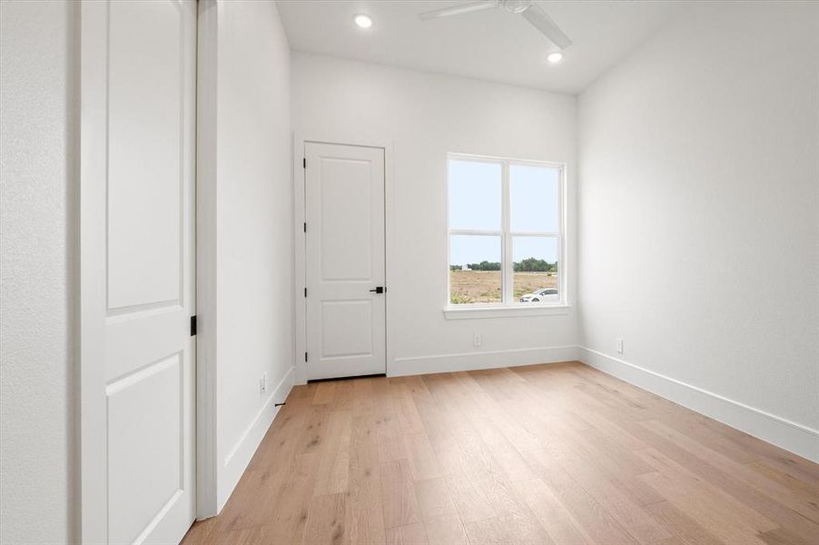 Empty room featuring ceiling fan and light wood-type flooring