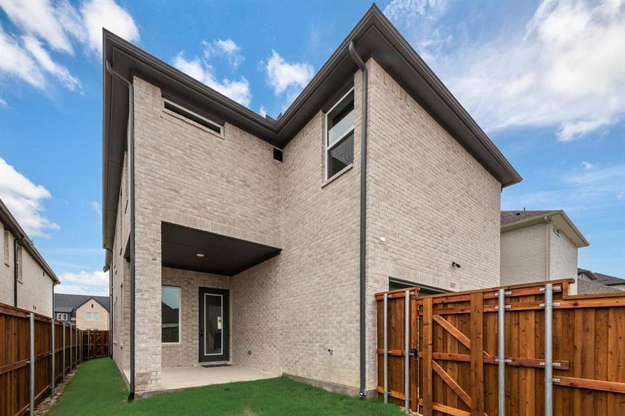 Rear view of house featuring a patio area, brick siding, a fenced backyard, and a gate Rear view of house featuring a patio area, brick siding, a fenced backyard, and a gate