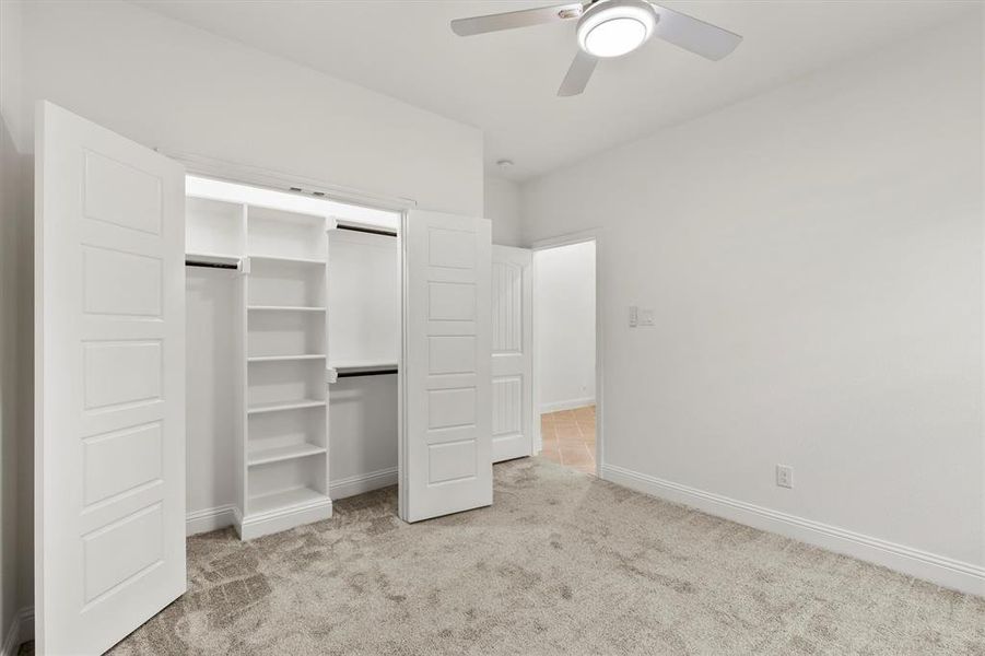 Unfurnished bedroom featuring a closet, ceiling fan, and light carpet