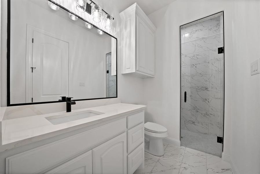 Master bathroom featuring light marble finish floors, vanity, and a marble finish shower