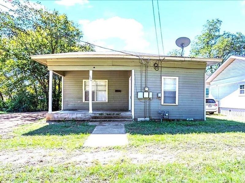 View of front facade featuring covered porch and a front lawn