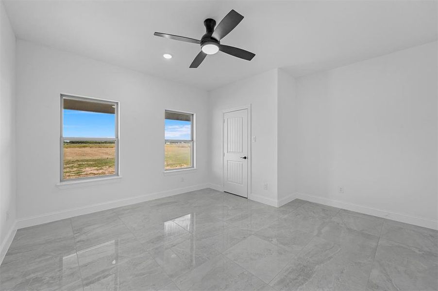 Unfurnished bedroom with ceiling fan and light tile patterned floors