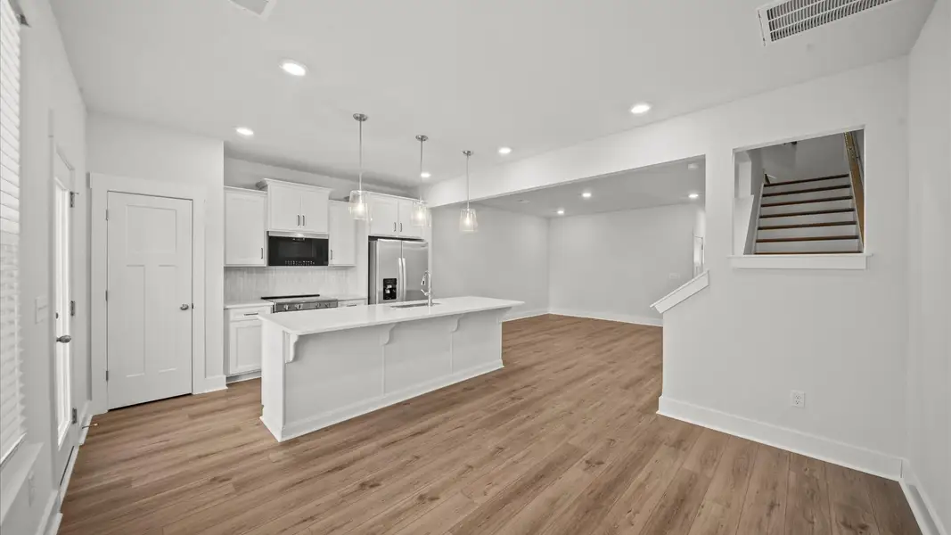 Tasteful design meets functional luxury in this kitchen with a 9-foot island and modern pendant lighting