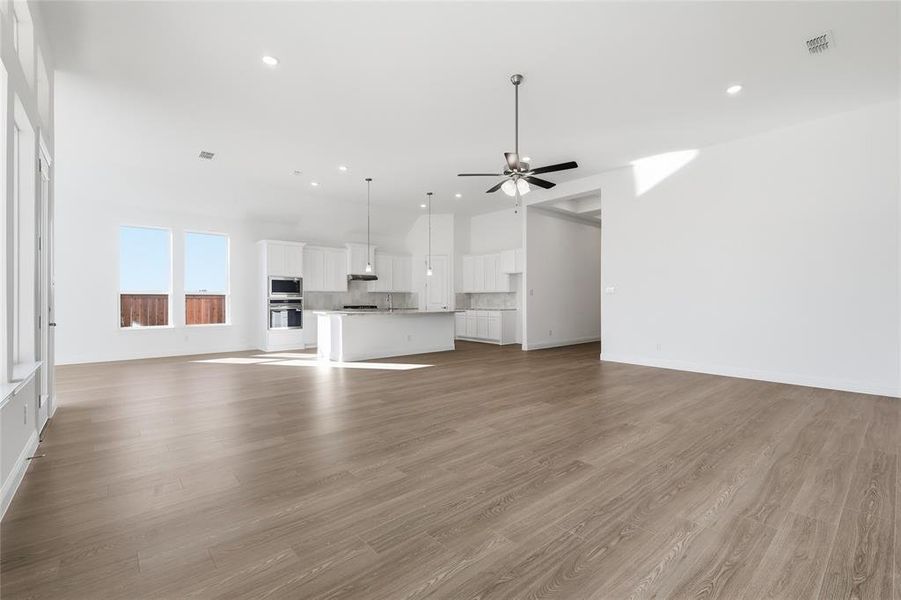 Unfurnished living room with light wood-style flooring, recessed lighting, and a ceiling fan Unfurnished living room with light wood-style flooring, recessed lighting, and a ceiling fan