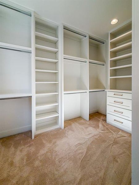 Built-in closet system featuring multiple shelving units, hanging rods, recessed lighting, and integrated drawer storage with brushed nickel pulls