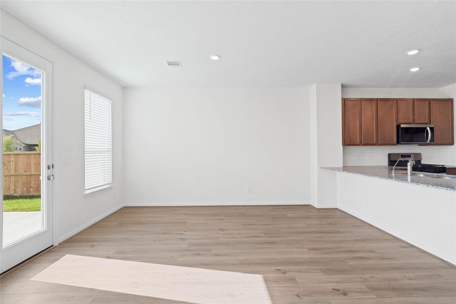 Start your day with a warm cup of coffee and quality time in this charming dining area! Highlights include a large window with blinds, custom neutral paint, vinyl plank flooring, recessed lighting, high ceilings, and a convenient door leading to the rear patio and backyard. Start your day with a warm cup of coffee and quality time in this charming dining area! Highlights include a large window with blinds, custom neutral paint, vinyl plank flooring, recessed lighting, high ceilings, and a convenient door leading to the rear patio and backyard.