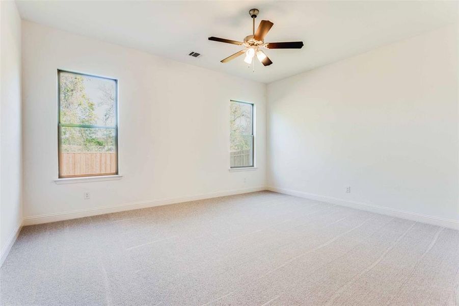 Unfurnished room featuring light carpet and ceiling fan