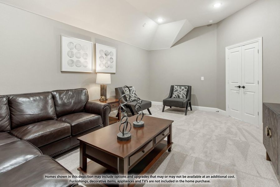 Living room with dark leather sofa, wood coffee table, gray accent chairs, and carpet flooring under a vaulted ceiling.