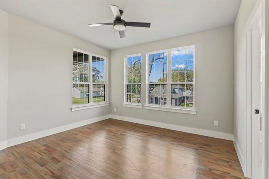 Empty room featuring wood finished floors and ceiling fan Empty room featuring wood finished floors and ceiling fan