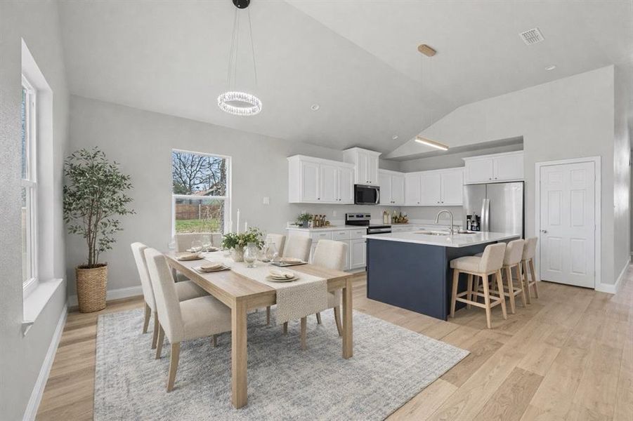 Dining space featuring light wood-style floors and lofted ceiling