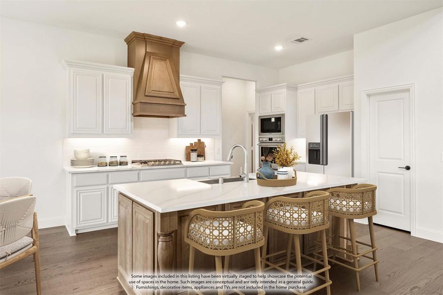 Kitchen with white cabinets, wood range hood, large island with seating, and stainless steel appliances on dark hardwood floors