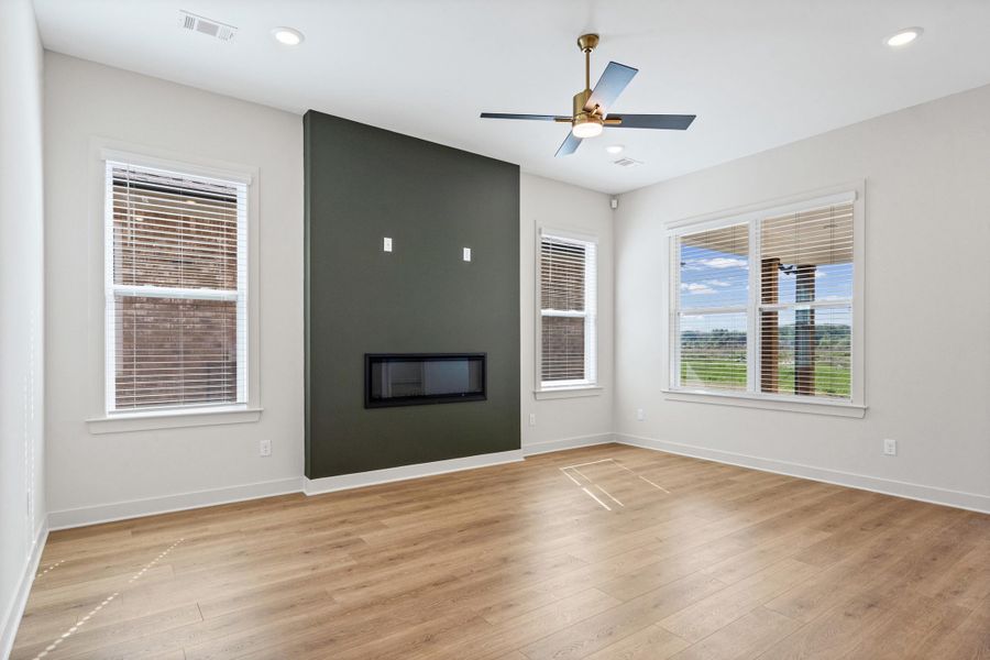 Spare room with a fireplace, ceiling fan, light wood-style flooring, and recessed lighting