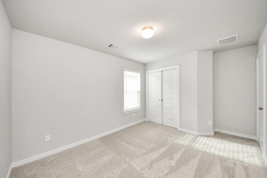 Secondary bedroom features plush carpeting, large windows that let in plenty of natural light, bright paint, and spacious closets. Sample photo of completed home with similar floor plan. Actual colors and selections may vary. Secondary bedroom features plush carpeting, large windows that let in plenty of natural light, bright paint, and spacious closets. Sample photo of completed home with similar floor plan. Actual colors and selections may vary.