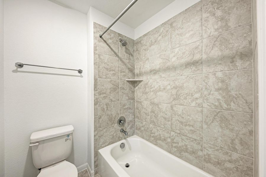 A well-appointed bathroom features a tub-shower combination with tasteful tile surround.