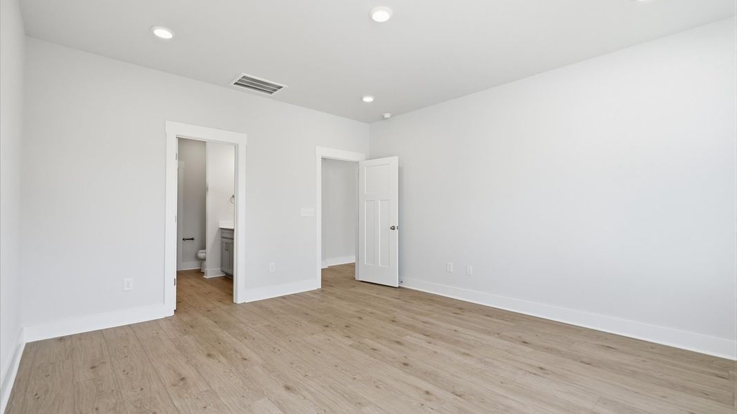 Serene and stylish primary bedroom featuring hardwood flooring and a thoughtful, modern layout near Lake Hartwell