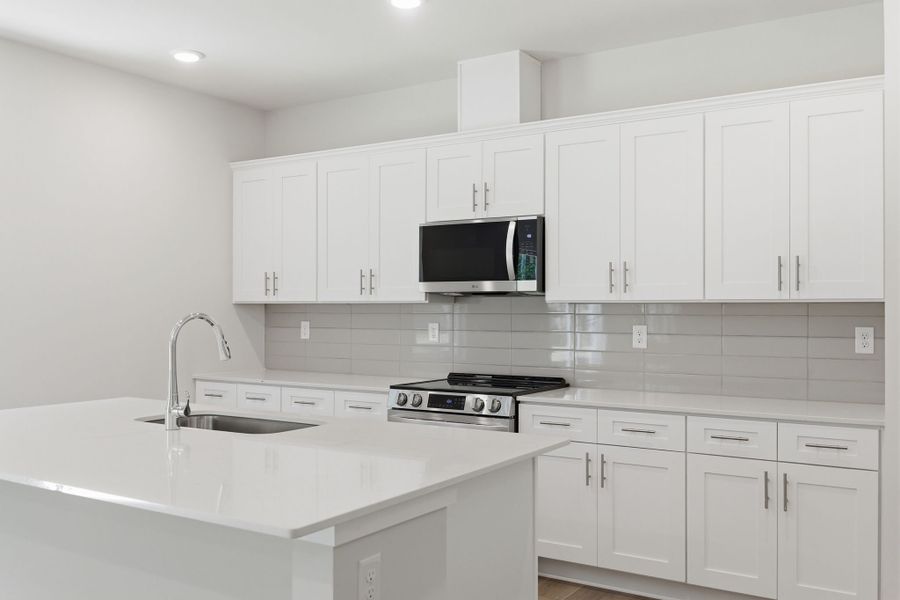 A kitchen with white cabinets.