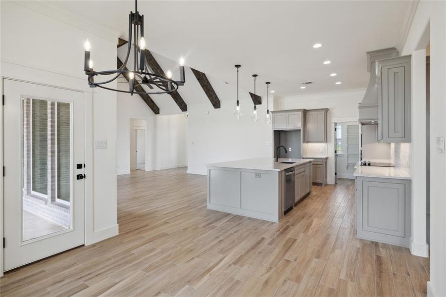 Kitchen featuring pendant lighting, a kitchen island with sink, light wood-type flooring, and sink