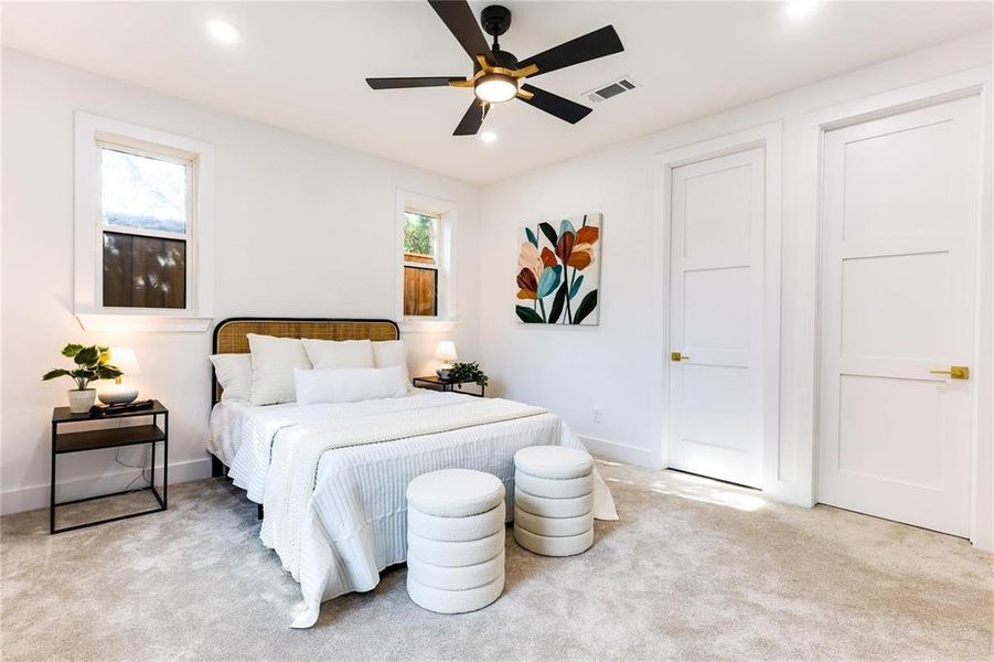 Carpeted bedroom featuring ceiling fan