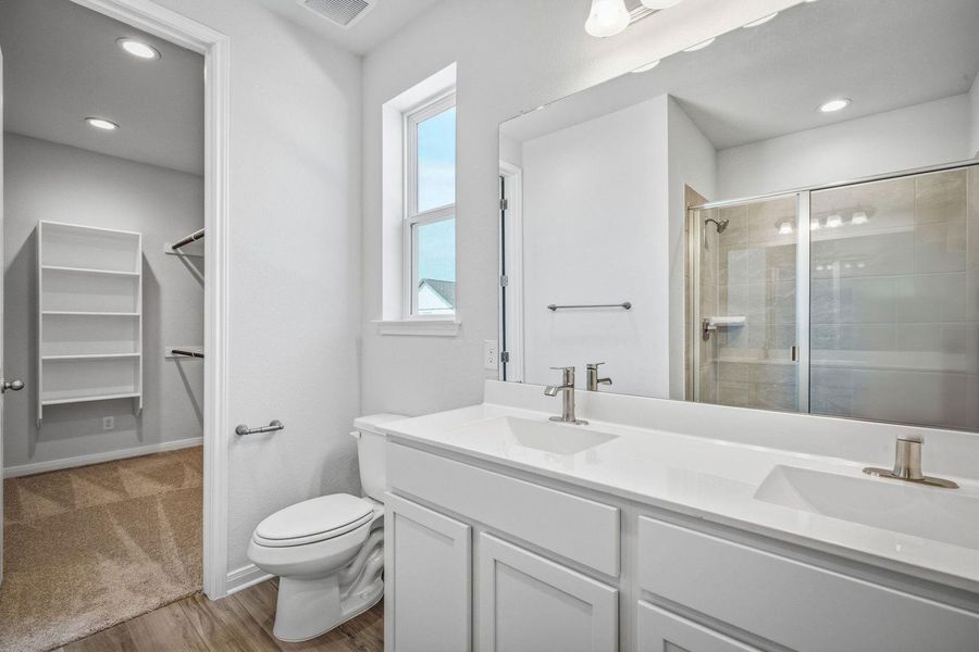 Double vanity sinks and clean countertops define this sleek, modern bathroom space. Double vanity sinks and clean countertops define this sleek, modern bathroom space.