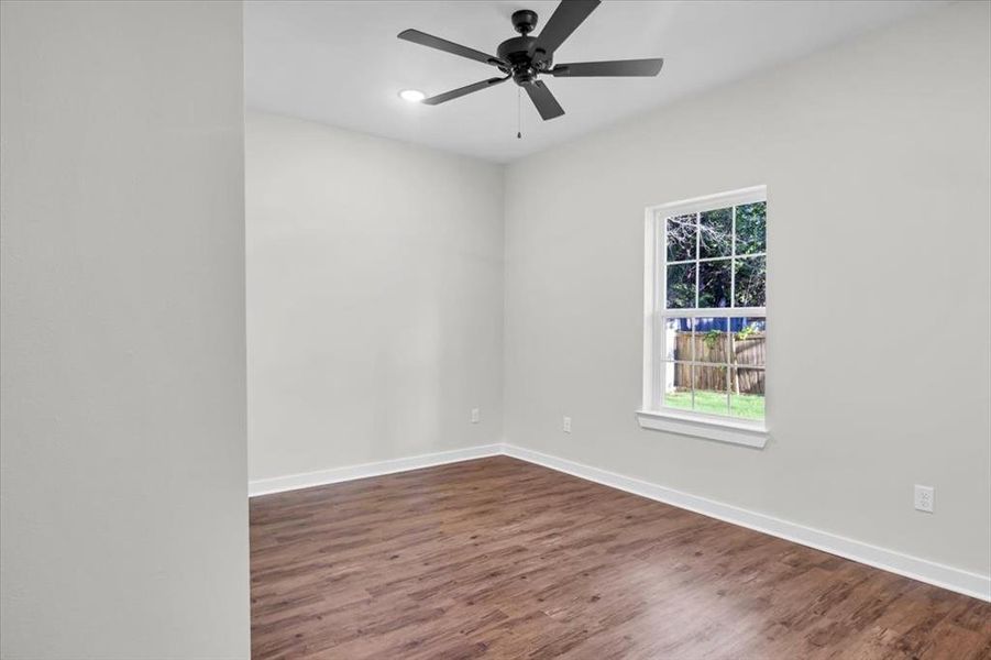 Spare room with dark wood-style floors, baseboards, ceiling fan, and recessed lighting
