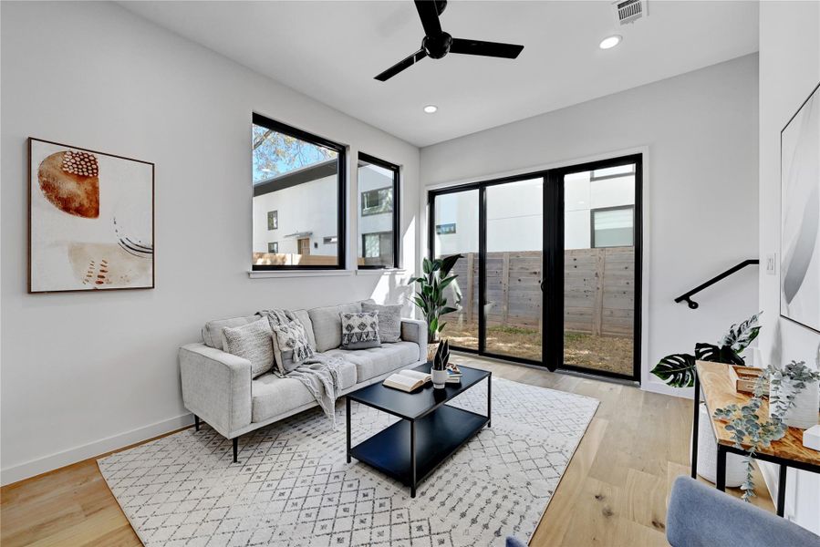Living area with ceiling fan, light wood finished floors, and recessed lighting