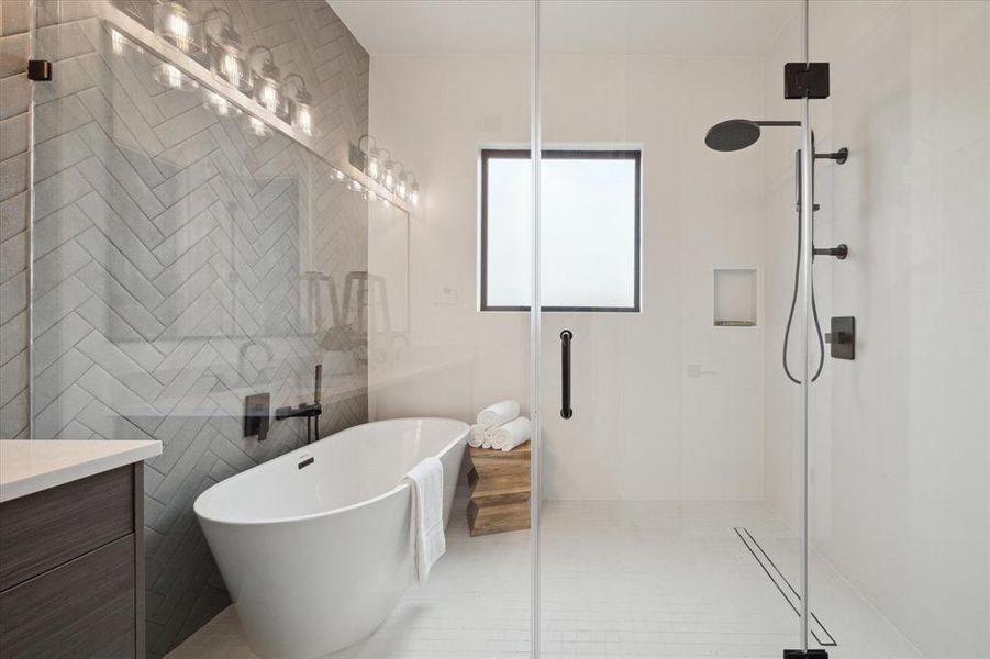 The primary bathroom features a relaxing soaking tub, large separate shower, herringbone pattern tiles, quartz countertops, double sinks, and two extra large walk-in closets!!