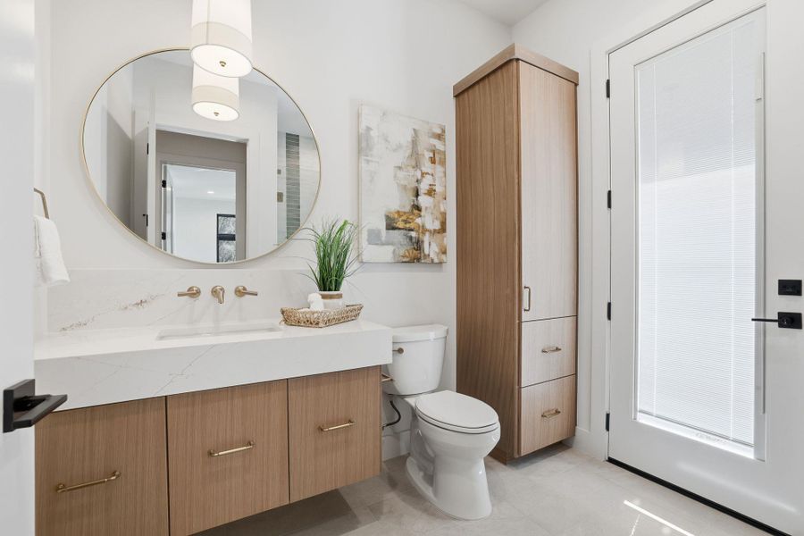 Half bathroom with vanity, light tile patterned floors, and backsplash