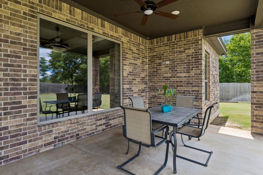 A generous covered patio creates a comfortable place to gather, unwind, and enjoy the outdoors in every season.