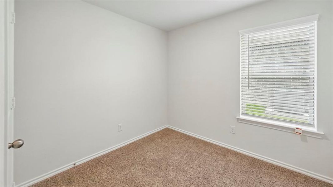 Neutral wall paint with textured carpeting and white baseboards