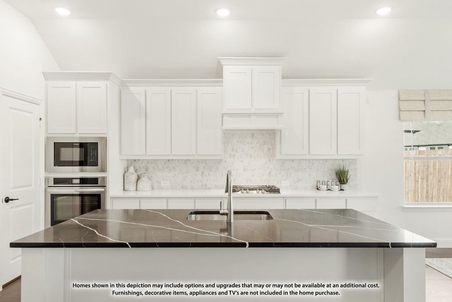 Kitchen with white cabinets, dark marble island, tile backsplash, and built-in stainless steel appliances Kitchen with white cabinets, dark marble island, tile backsplash, and built-in stainless steel appliances