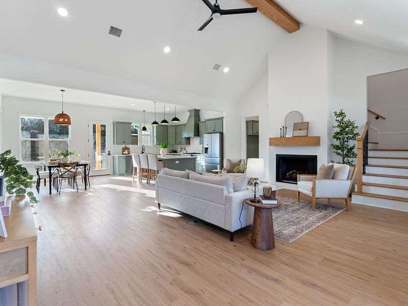 Living room featuring a ceiling fan, a fireplace, light wood finished floors, and recessed lighting