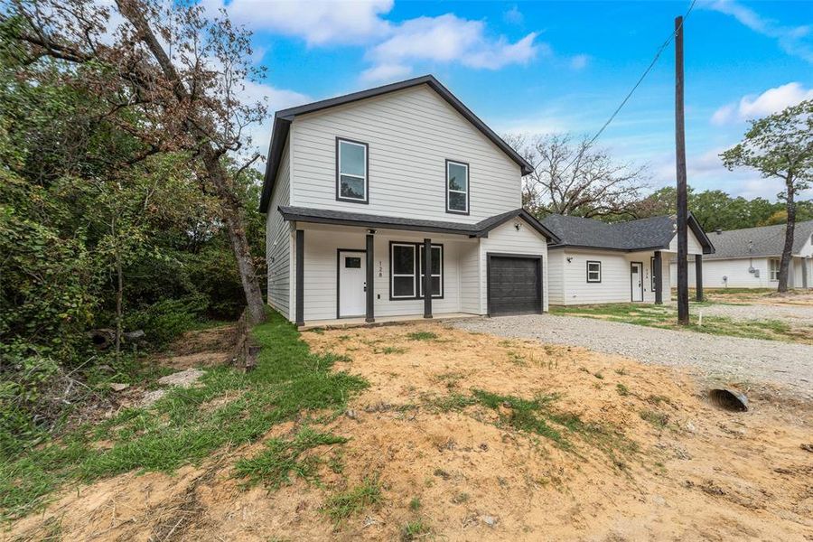 Front of property with a porch and a garage