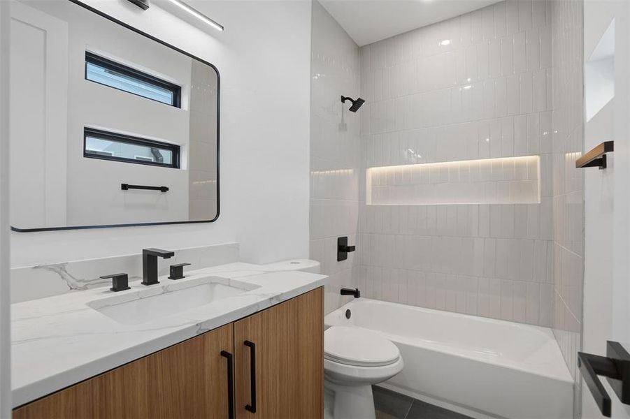 Sleek guest bath features modern touches and vanity for storage