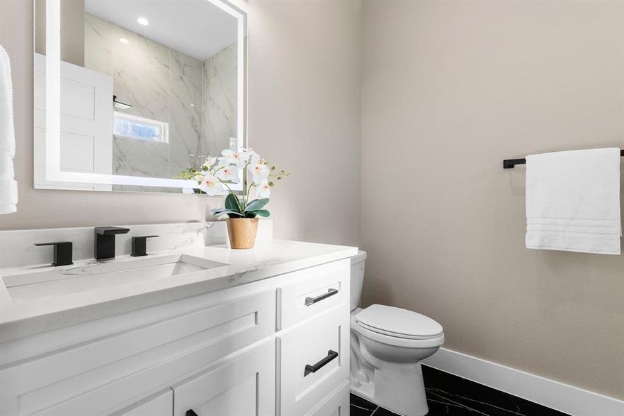 Bathroom featuring vanity, toilet, and walk in shower