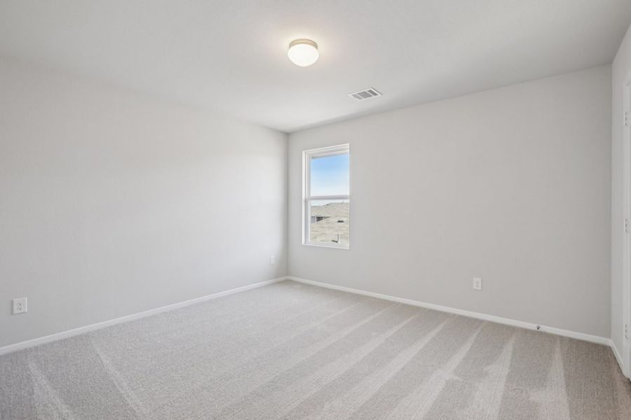 Image of a bedroom with grey walls, tan carpeting, a window and white trim