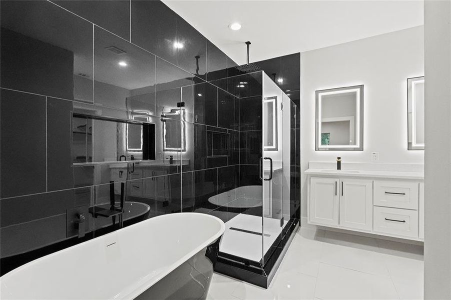 Bathroom with tile patterned floors, vanity, independent shower and bath, and tile walls