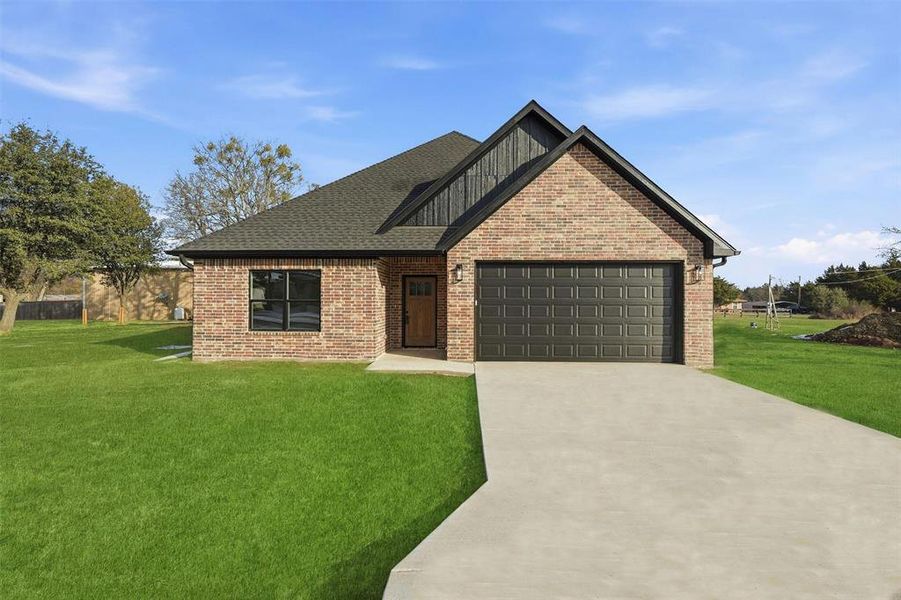 View of front facade with brick siding, driveway, a front lawn, roof with shingles, and an attached garage View of front facade with brick siding, driveway, a front lawn, roof with shingles, and an attached garage