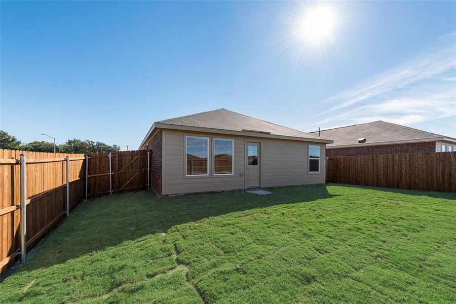 Rear view of property with a lawn