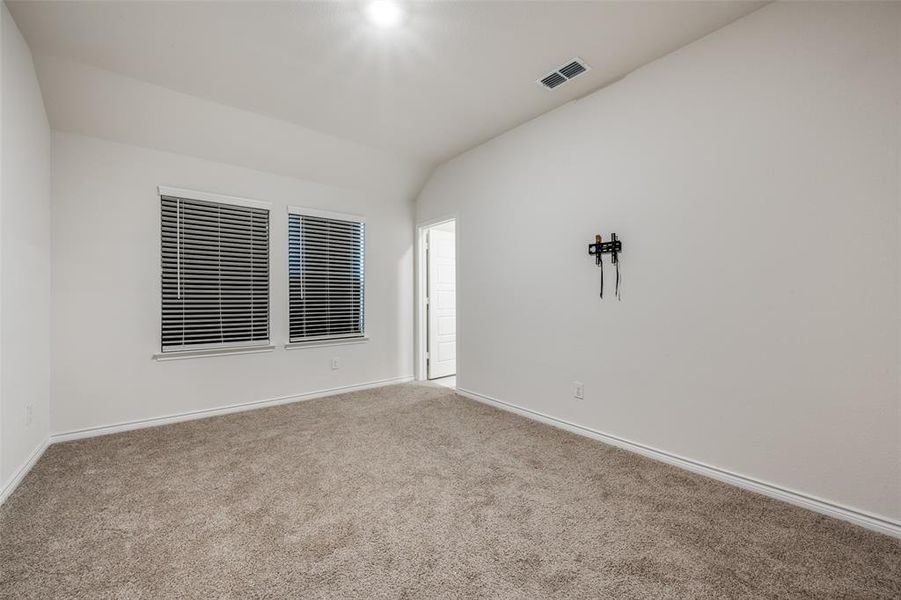 Unfurnished room with lofted ceiling and carpet flooring