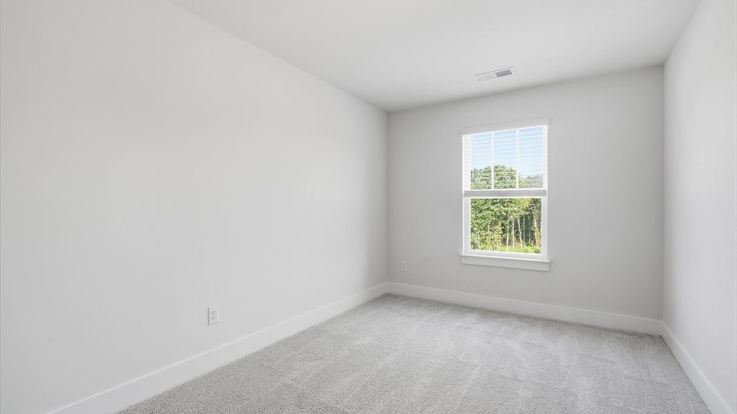 Refined bedroom design with large windows for daylight-filled mornings and peaceful views by DRB Homes