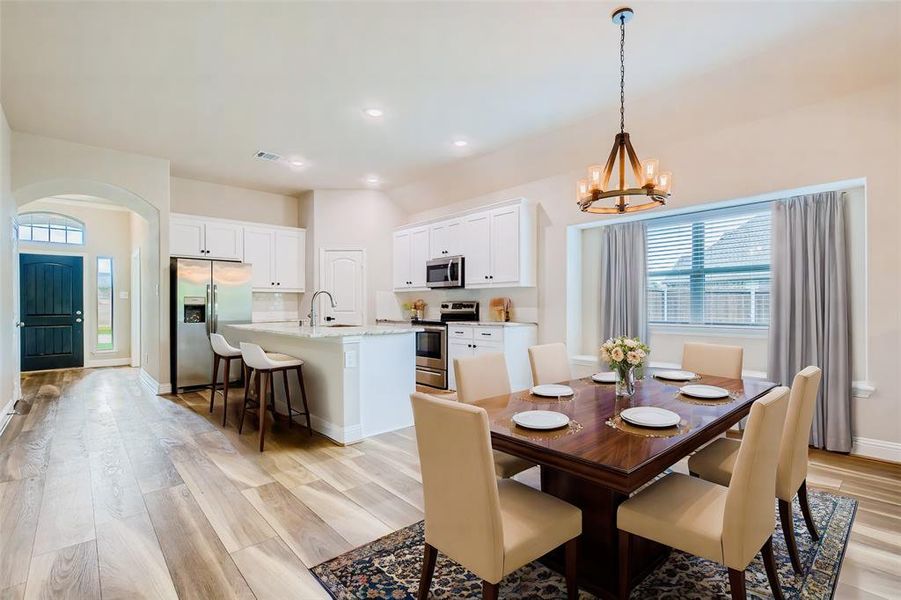 Dining area (Virtually Staged) featuring a chandelier, sink, and light hardwood / wood-style floors