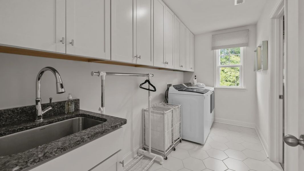 Ample laundry room with sink and plentiful cabinetry, in the Townsend Design by DRB Homes at Lakeside Glen in York, SC