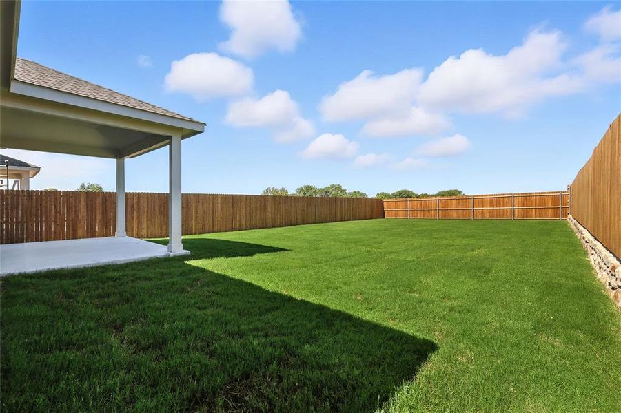 Fenced backyard with a patio area Fenced backyard with a patio area